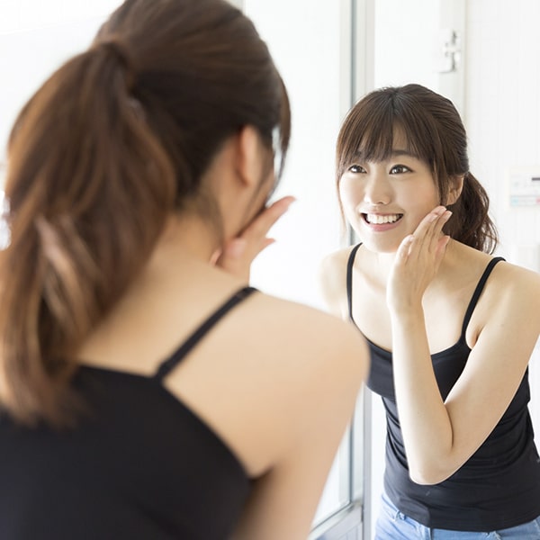 A woman looking at her new smile in the mirror